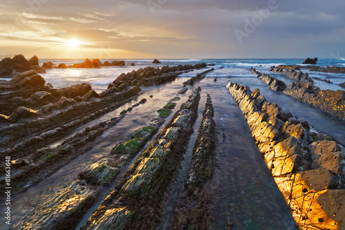 rocks in Barrika beach with golden reflections