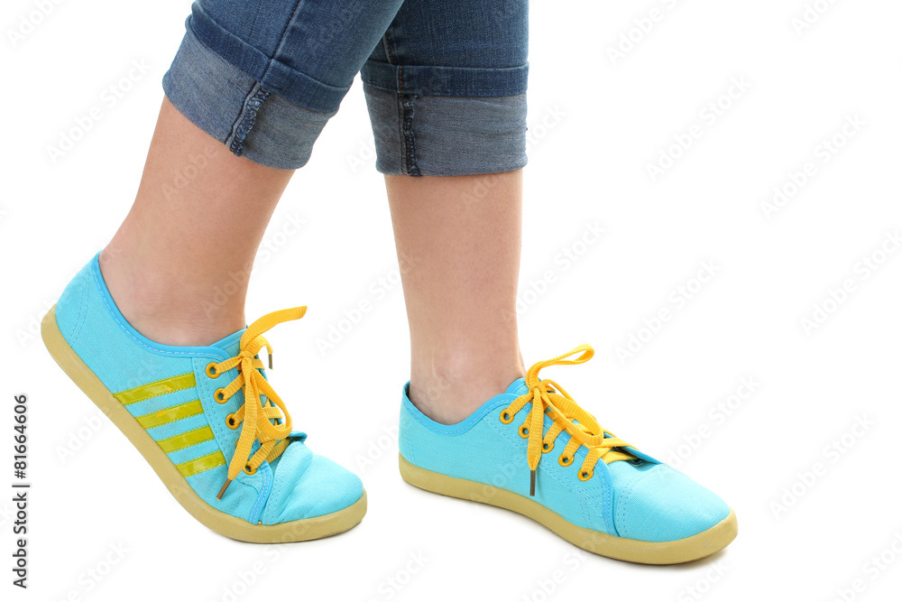 Blue sneakers on girl, young woman legs, isolated