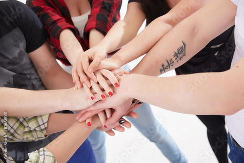 group of students in a circle of hands stacked together
