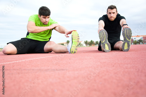 Men stretching in running track