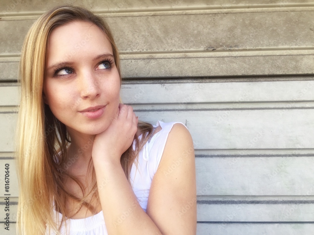 Naklejka premium Nahdenkliche Frau lehnt an Wand