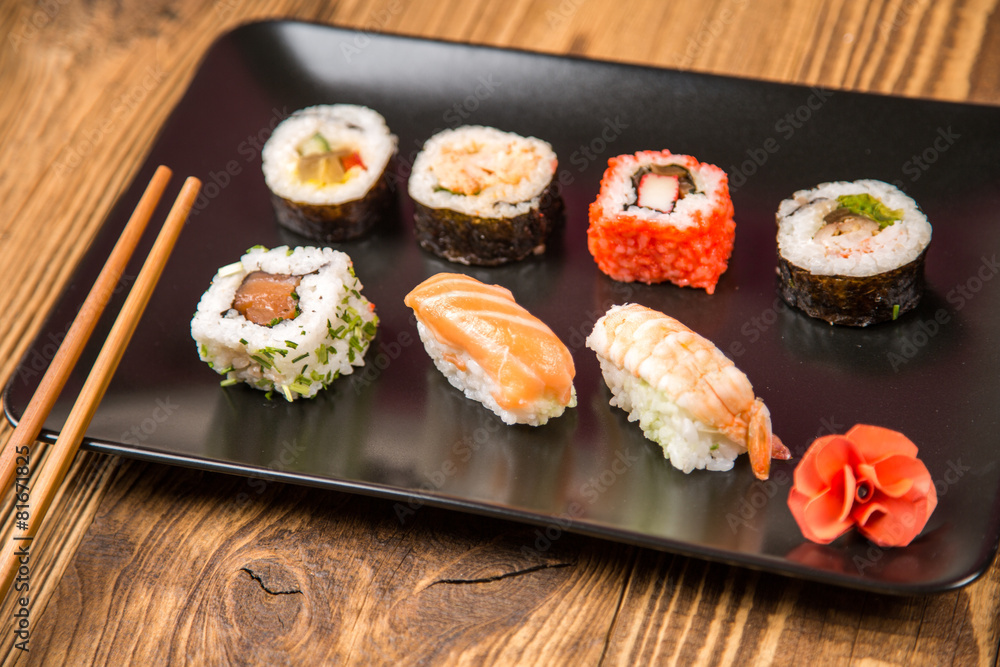 Sushi pieces collection with bamboo chopsticks, isolated on wooden table Sushi pieces collection with bamboo chopsticks, isolated on wooden table