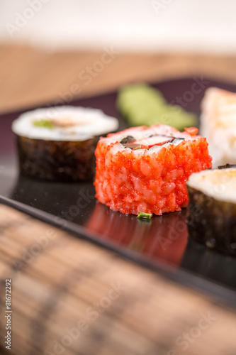 fresh Japanese tasty sushi roll set with chopsticks on wooden ta