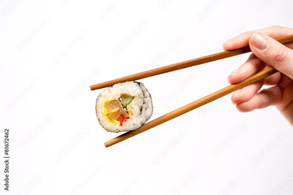 Hand holding Sushi roll with bamboo chopsticks isolated on white Hand holding Sushi roll with bamboo chopsticks isolated on white