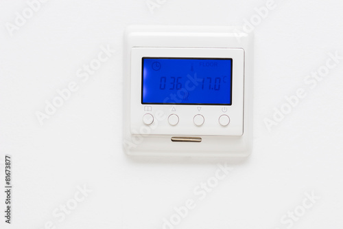 Plastic thermostat on a plain white wall