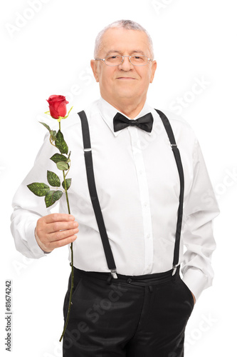 Elegant senior gentleman holding a red rose