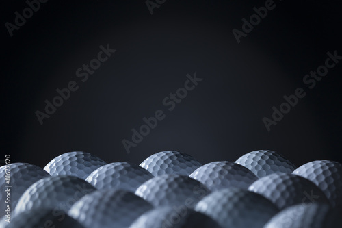 Group of golf balls isolated on black background.