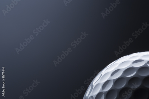 Stylish macro golf ball isolated on blank dark blue background.