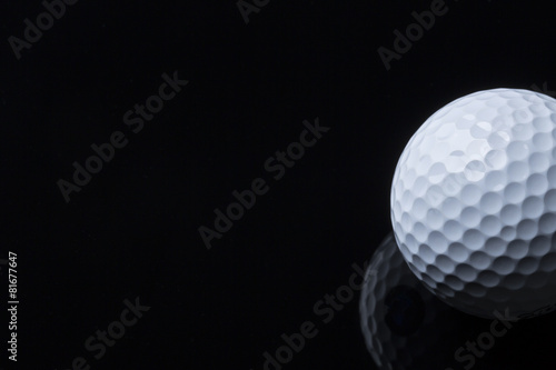Golf ball isolated on dark background with space for text.