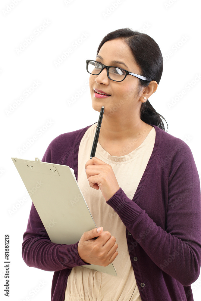 Young woman thinking while taking notes against white background Young woman thinking while taking notes against white background