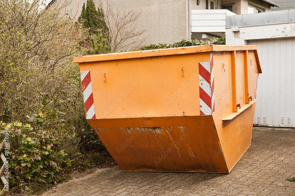 Ein grosser oranger Container steht in einer Garagenauffahrt Ein grosser oranger Container steht in einer Garagenauffahrt