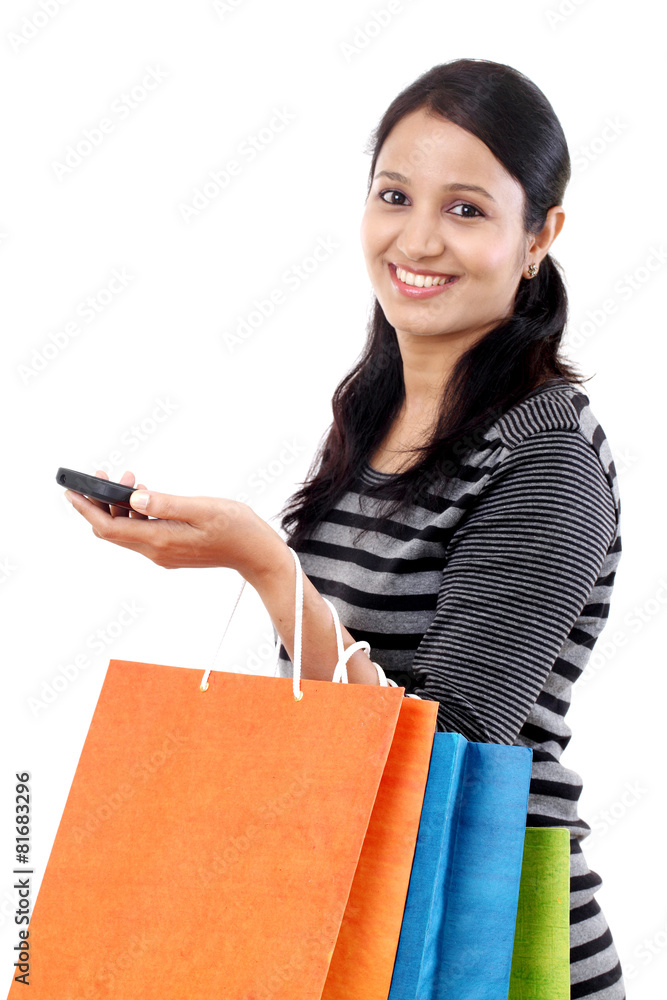 Young woman with mobile phone and holding shopping bags Young woman with mobile phone and holding shopping bags