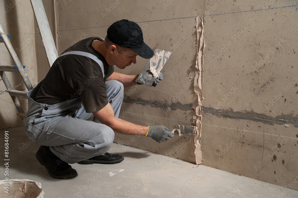 Worker gets plaster on the wall Worker gets plaster on the wall