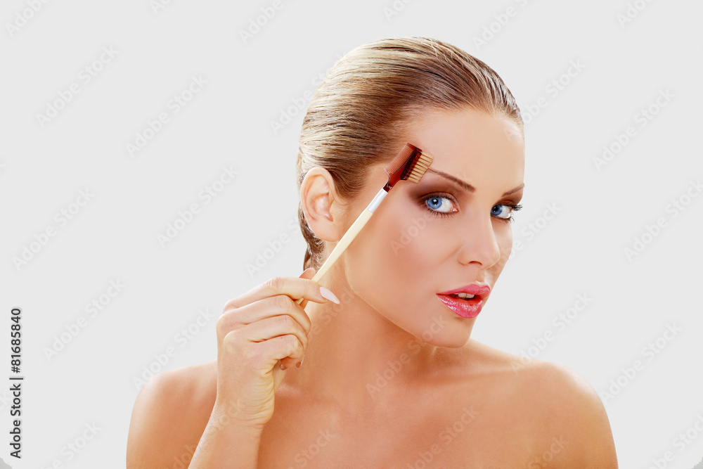 Naklejka premium Beautiful young woman with brushes for make-up