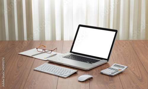 Blank screen laptop computer with office accessories on wooden t