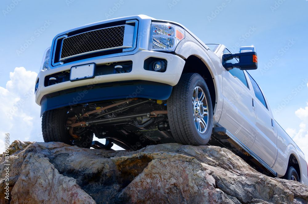White truck on cliff edge showing undercarriage - obrazy, fototapety, plakaty 