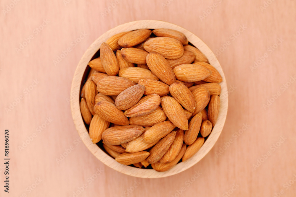 Fresh almonds in a wooden bowl Fresh almonds in a wooden bowl