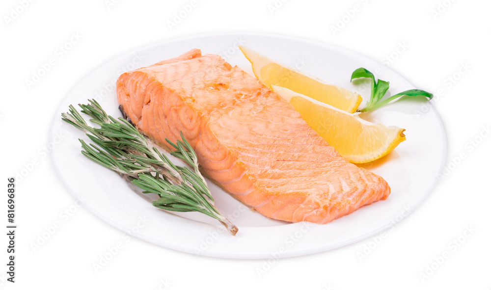 Fried salmon fillet on plate with lemon.