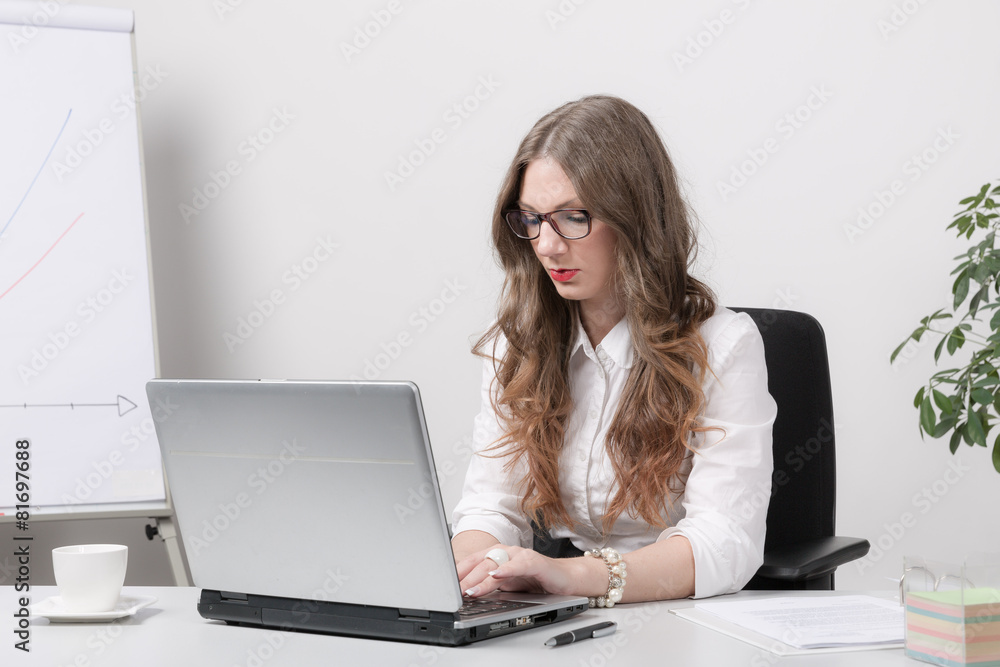 Junge Frau arbeitet mit Brille am Computer