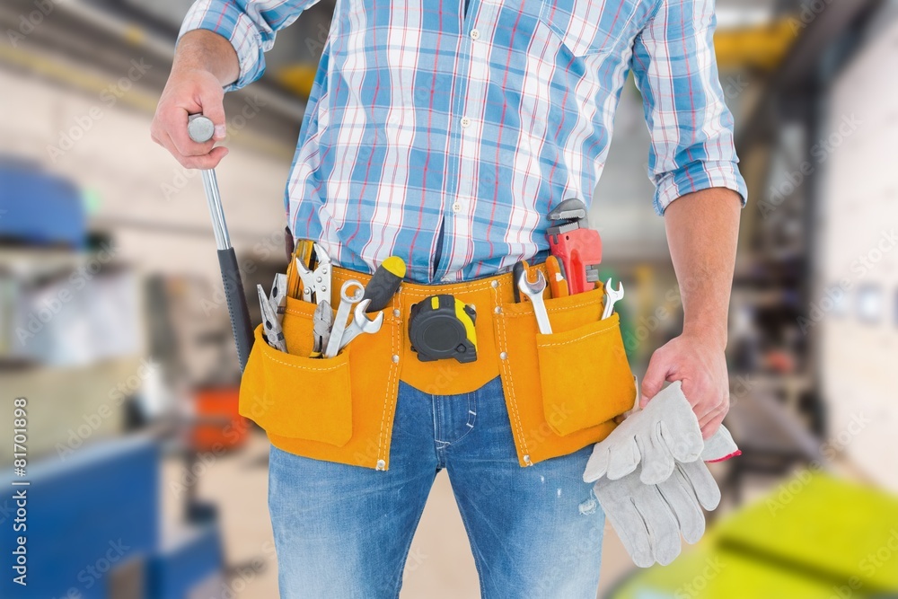midsection of handyman holding hammer and gloves midsection of handyman holding hammer and gloves