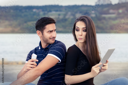 Tableau sur toile Secretive Couple with Tablet and Smartphone