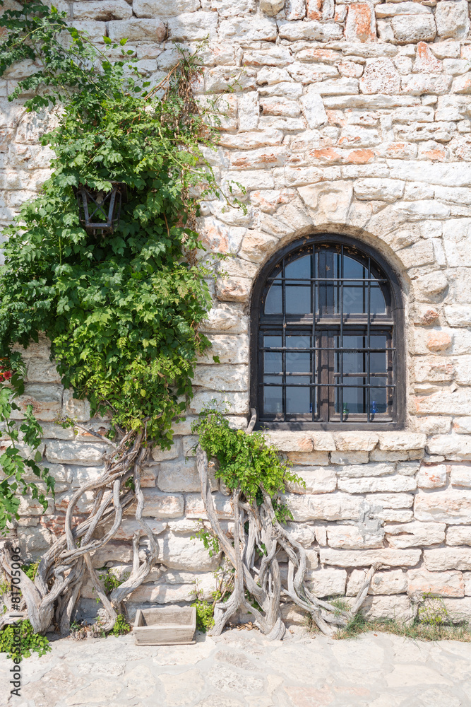 Old wooden window on stonewall, Balchik, Bulgaria Old wooden window on stonewall, Balchik, Bulgaria