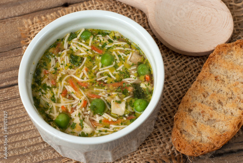 Soup with pasta and vegetables on old wooden table