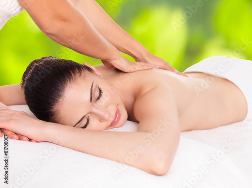 Woman having massage of body in nature spa