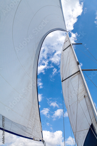 Sails filled with wind against the sky with clouds