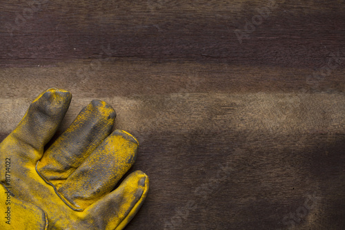 old dirty leather work glove on wood background