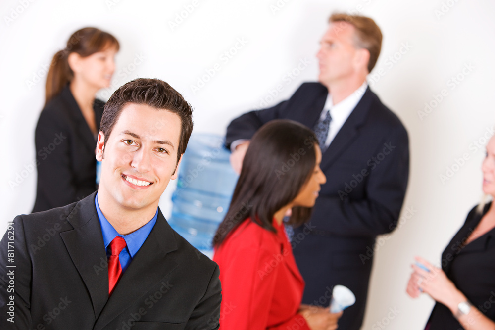 Business: Smiling Businessman with Group Around the Water Cooler Business: Smiling Businessman with Group Around the Water Cooler
