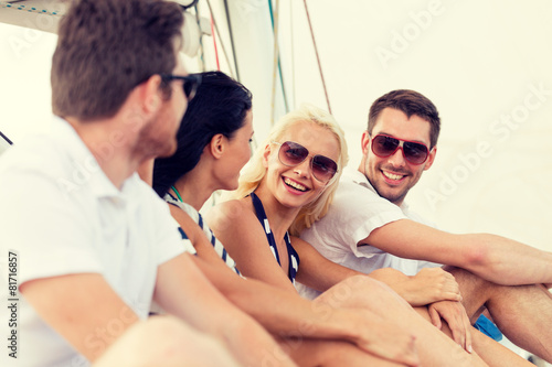 smiling friends sitting on yacht deck