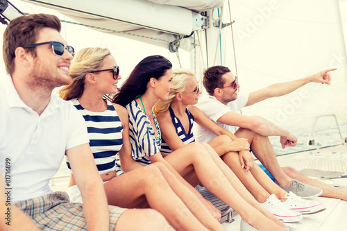 smiling friends sitting on yacht deck © Syda Productions