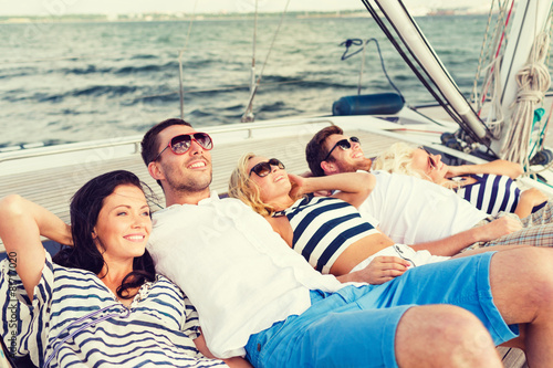 smiling friends lying on yacht deck © Syda Productions