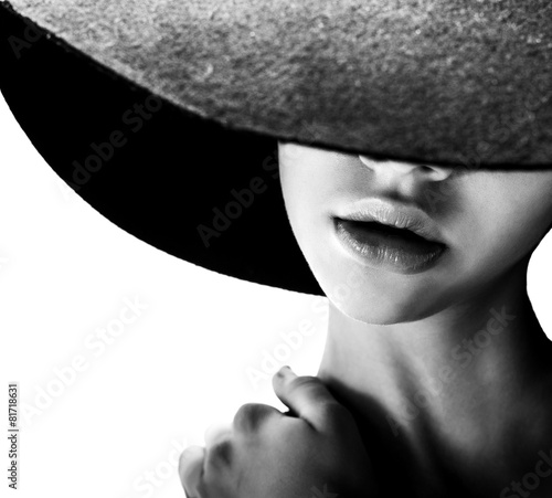 girl in black hat touching face and lips