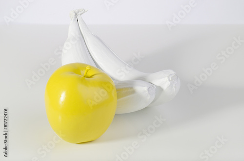 Yellow apple and two white bananas.