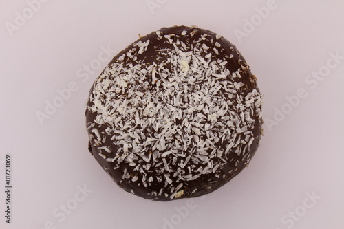 Single chocolate donut with sprinkled coconut pieces