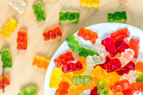 gummy bears on a white plate and wooden table