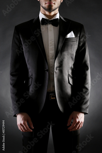 Elegant man in suit on dark background © Africa Studio