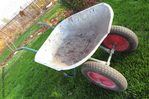 Modern two-wheeled wheelbarrow on the fresh lawn 