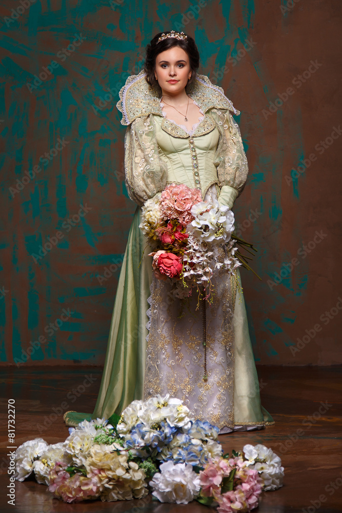 beautiful haughty queen in royal dress.Princess holding a large bouquet of flowers.