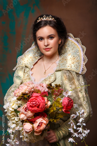 beautiful haughty queen in royal dress.Princess holding a large bouquet of flowers.