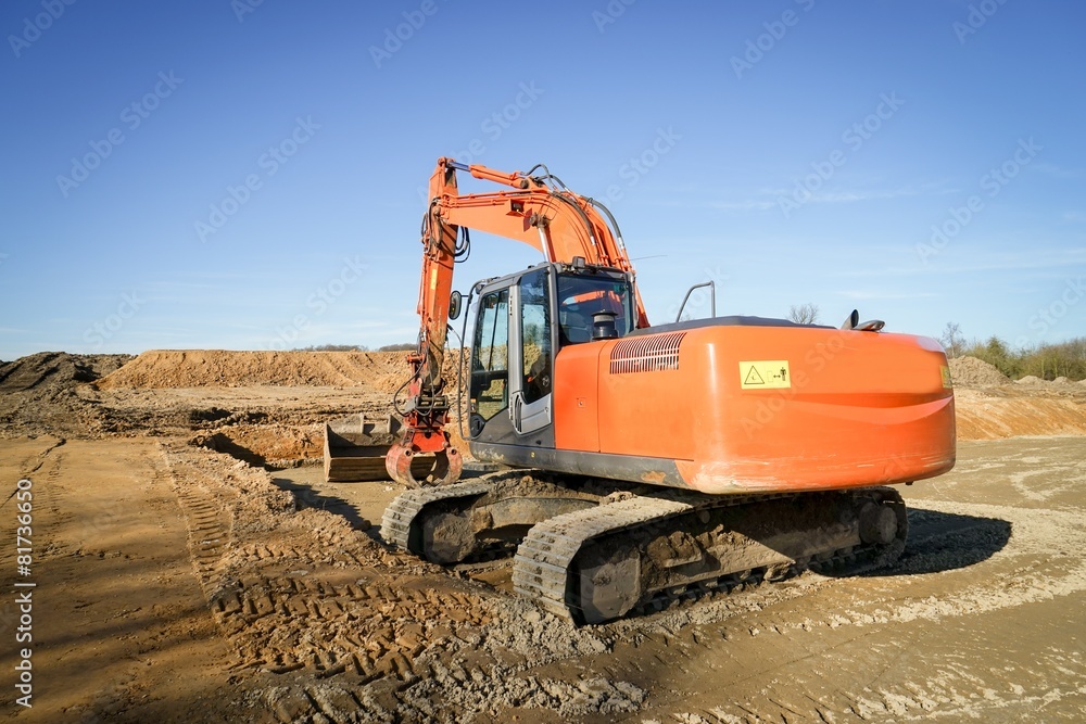 Orange Baumaschine mit Baggerarm Orange Baumaschine mit Baggerarm