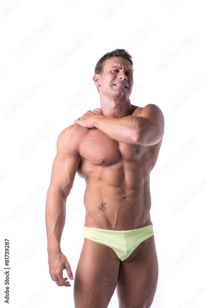 Muscular handsome man holding his shoulder in pain Muscular handsome man holding his shoulder in pain