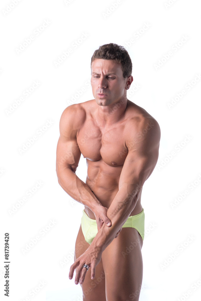 Muscular handsome man holding his arm in pain Muscular handsome man holding his arm in pain
