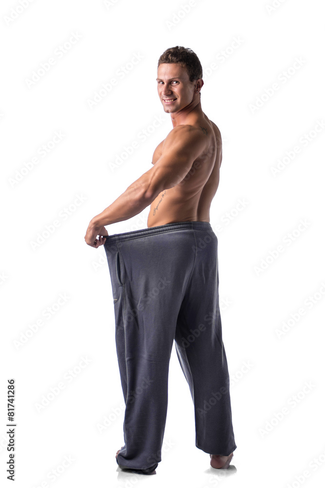 Fototapeta premium Shirtless young male bodybuilder has lost weight, wearing large