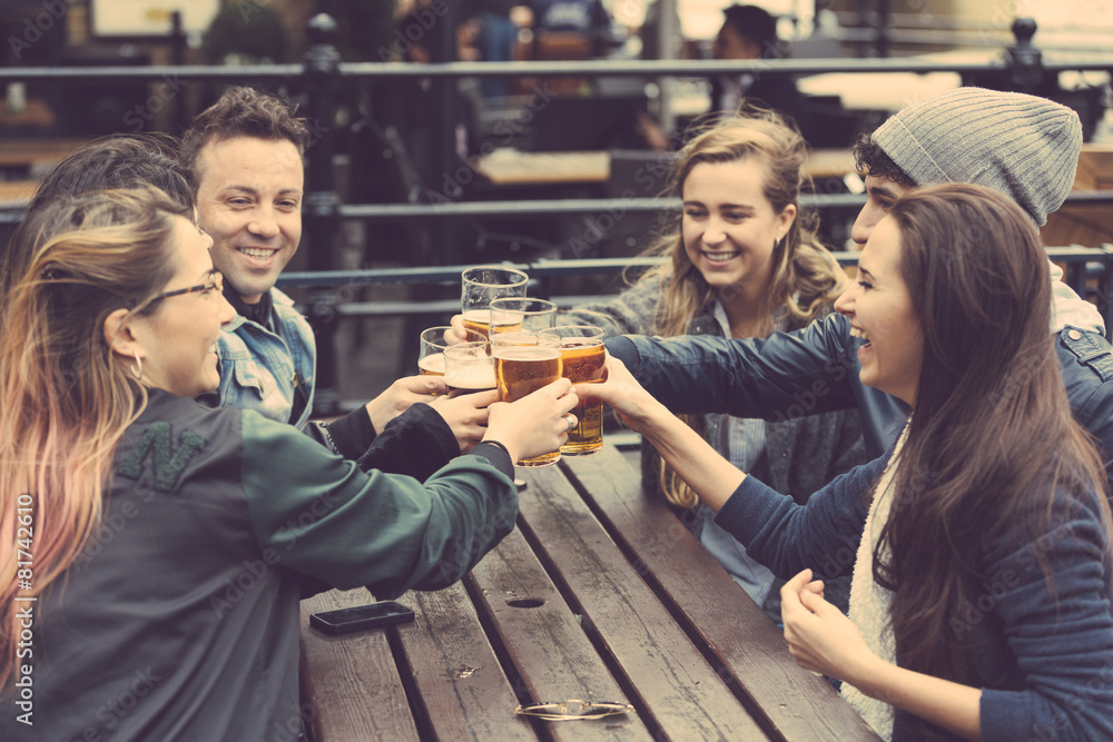 Group of friends enjoying a beer at pub in London - obrazy, fototapety, plakaty 