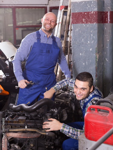 Professional mechanics repairing car