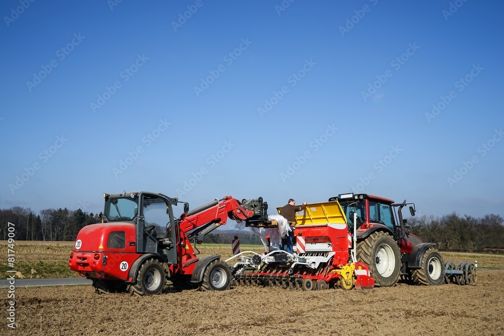 Obraz premium Ackerbau, Landwirt mit Hoftrak füllt Saatgut in Sämaschine