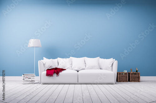 Couch und Stehlampe vor blauer Betonwand